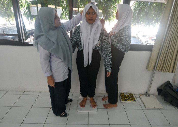 Dalam CKG, petugas juga melakukan pengukuran tinggi serta berat badan murid guna menghitung Indeks Massa Tubuh (IMT), sekaligus berfungsi untuk mengetahui status gizi, apakah sudah ideal, kurang, atau berlebih (obesitas). Keduanya berkaitan erat dengan risiko penyakit seperti diabetes, hipertensi, serta jantung. (Achmad Fazeri/Disway Jateng)