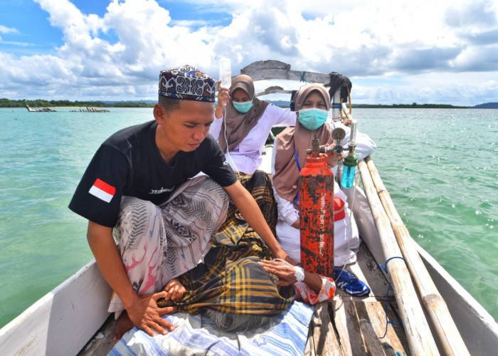 DEDIKASI NAKES: Dua bidan Polindes Sabuntan Indah Milasari dan Fatimah, didampingi relawan membawa pasien lansia, Mamah, menyeberang menuju Pulau Sapeken pakai perahu sebagai satu-satunya alat transportasi di Pulau Sabuntan, Selasa, 3 Juni 2025. Butuh waktu sekitar satu setengah sampai dua jam perjalanan, tergantung kondisi ombak dan jumlah mesin perahu yang digunakan. (Achmad Fazeri/Disway Jateng)